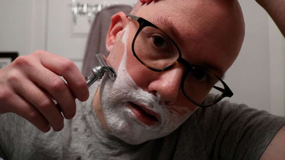 man shaving with a safety razor