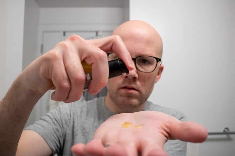 man putting taconic pre shave oil in palm